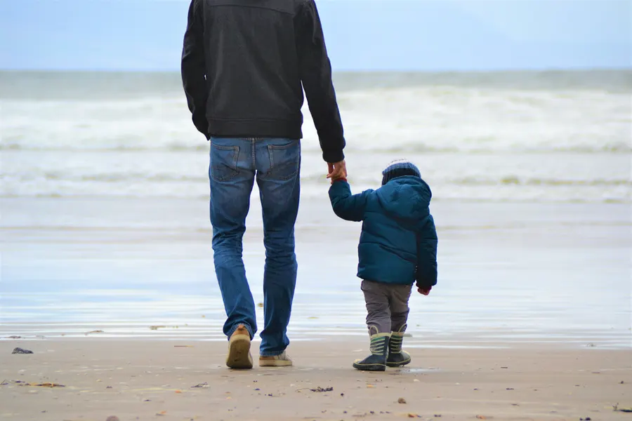 Parent walking hand-in-hand with a child