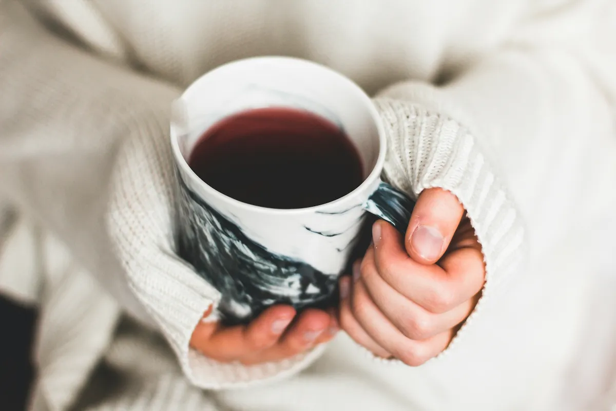 Hands holding a warm mug of tea